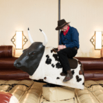 Man riding a mechanical bull at an event, showcasing entertainment options for parties and gatherings.
