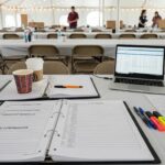 Organized tables and chairs under tent for school event planning in Charleston.